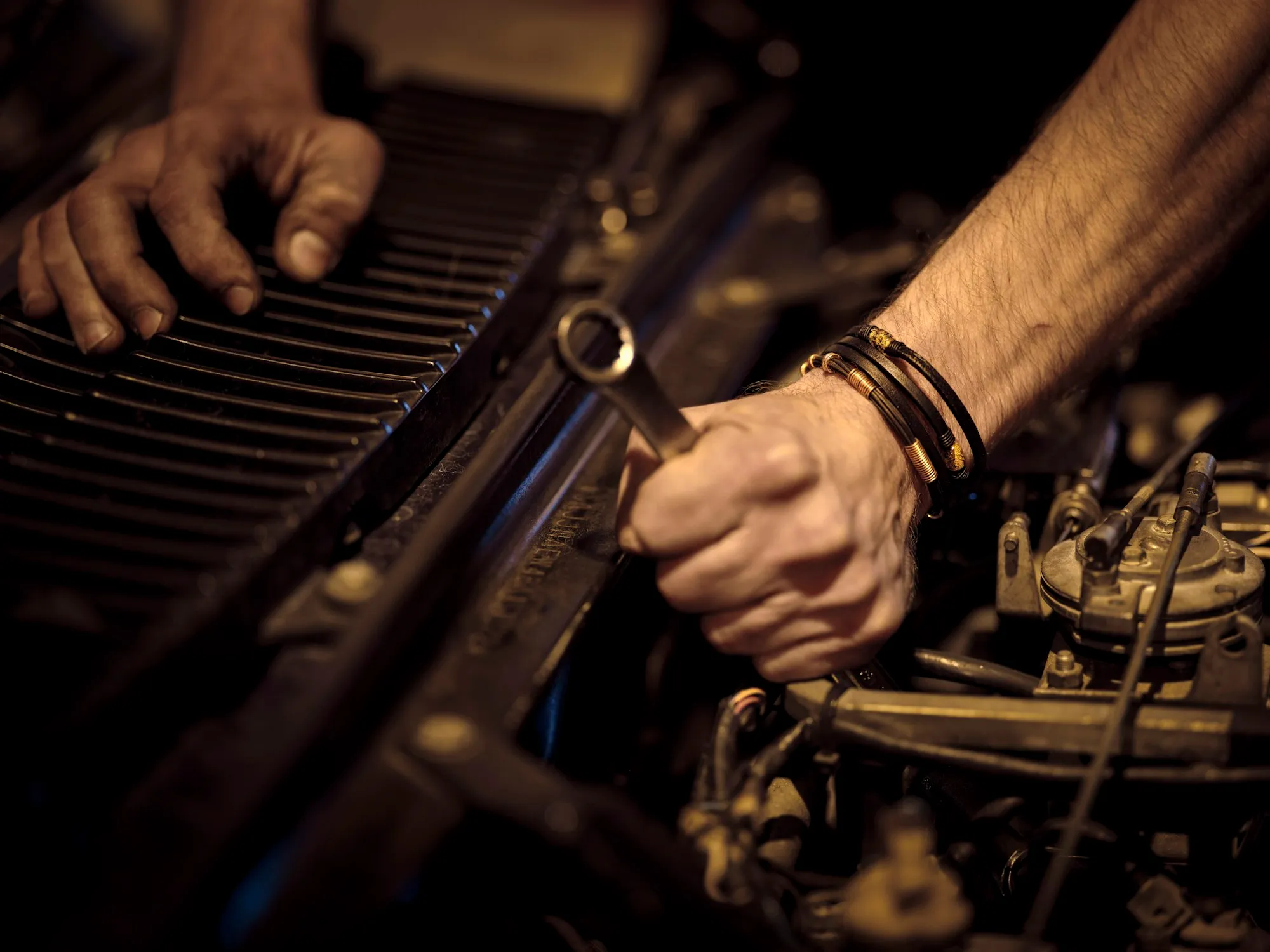 Mechanik dokręca kluczem element silnika